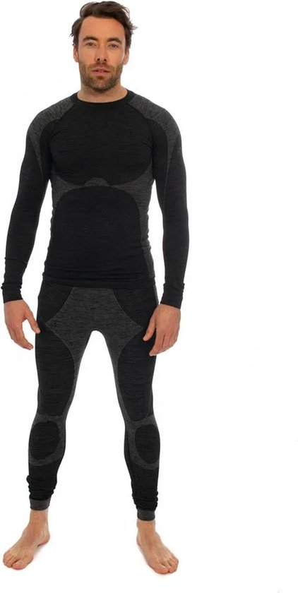 Man staat frontaal in een zwarte en grijs gemêleerde thermo set. Het shirt heeft een hoge kraag en de legging loopt tot de enkels. De set heeft contrasterende panelen.