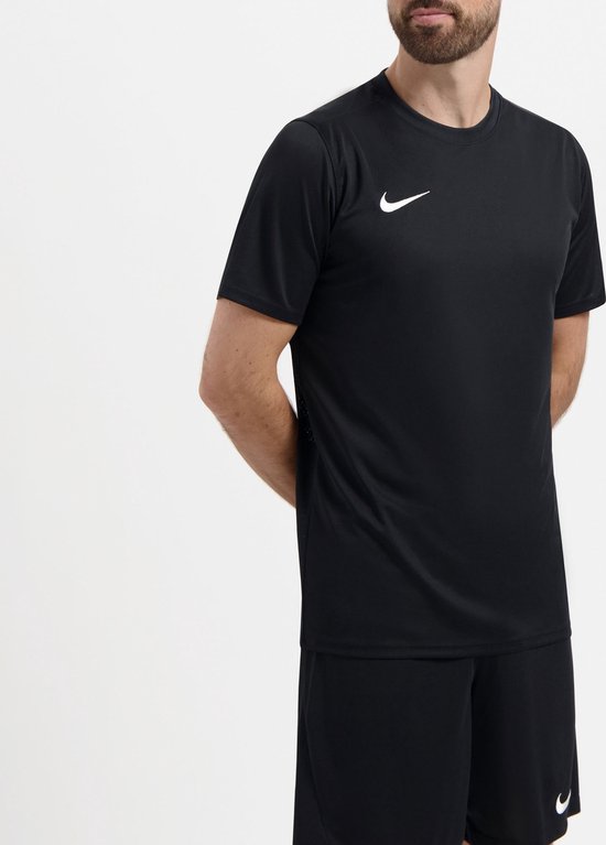 Homme barbu, vu de face, portant un t-shirt de sport noir et un short noir.