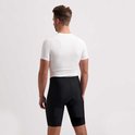 Man van achteren gezien, draagt een witte fietsjersey en zwarte fietsbroek.