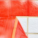 Oranje folie met tape wordt aangebracht op witte tegels.