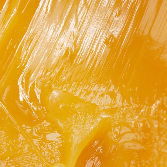 Een close-up van een glanzende, oranje textuur, met strepen en bubbels.