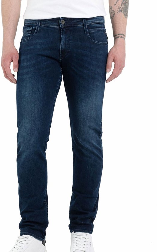 Man met donkerblauwe jeans en witte sneakers.