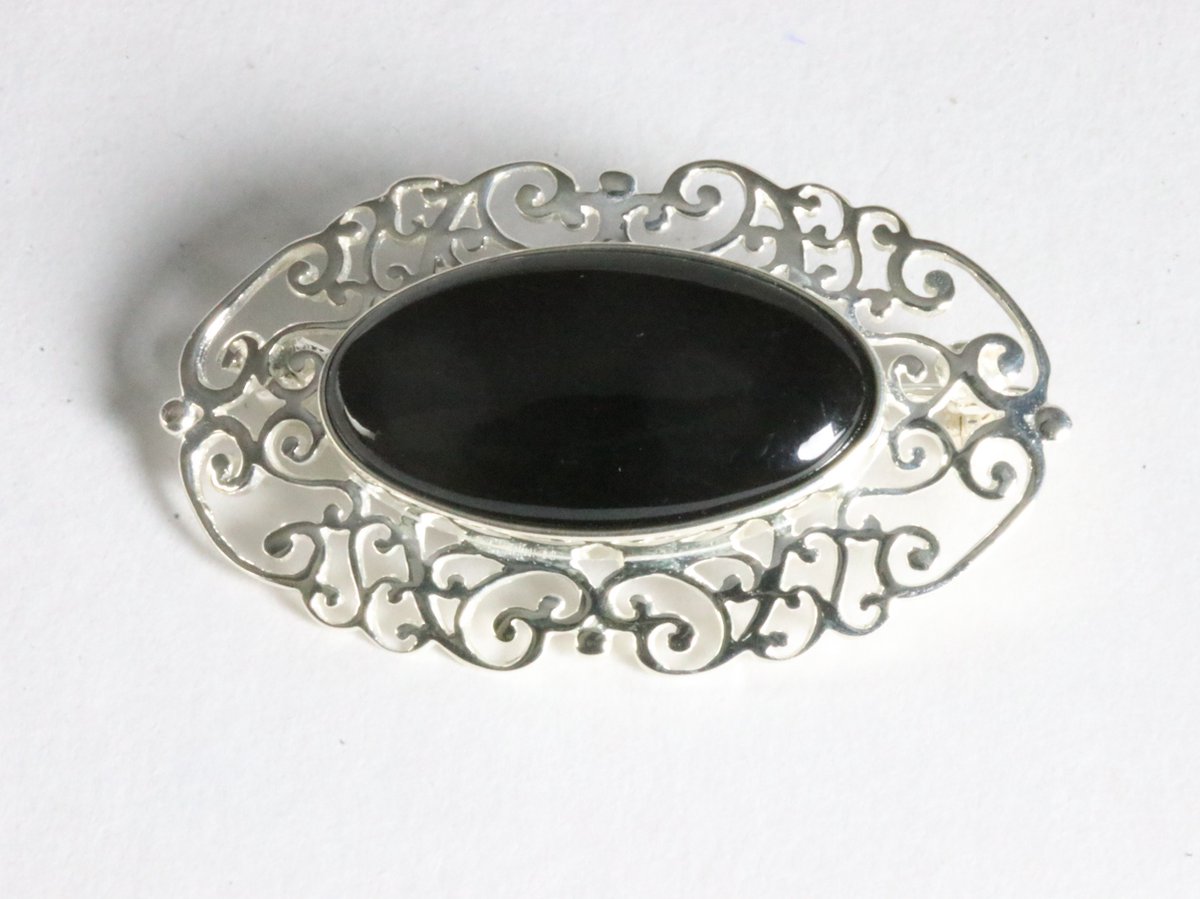 Opengewerkte zilveren broche met onyx