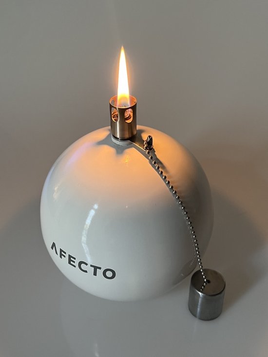 Witte, ronde Afecto olielamp met vlam, metalen ketting met dop, op tafel.