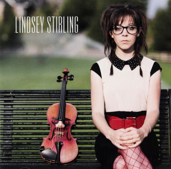 Lindsey Stirling zit op een bankje met een viool naast haar. Ze draagt een bril en een rode riem.