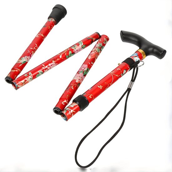 Een opvouwbare wandelstok met een rood met bloemenmotief en een zwart handvat.