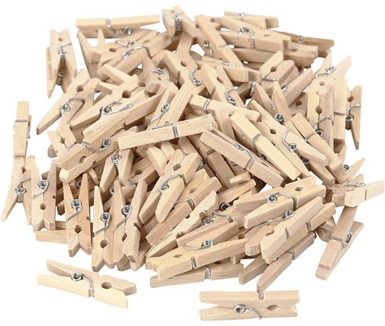 Un tas de petits clips en bois clair avec des ressorts métalliques, disposés sans ordre précis sur un fond blanc.
