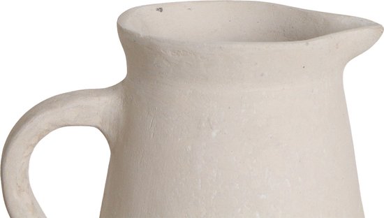 Crèmekleurige, ruwe keramische schenkkan met een handvat en tuit. Close-up.