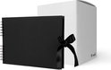 Een zwart plakboek met een zwarte lintstrik, naast een open witte geschenkdoos.
