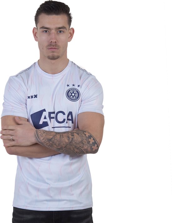 Model draagt een wit voetbalshirt met blauw logo en strepenpatroon, met 'AFCA' op de voorkant.