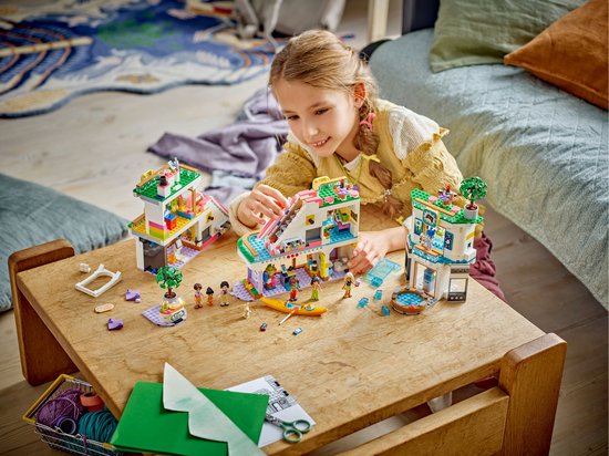 Un enfant construit un centre commercial LEGO Friends Heartlake City.