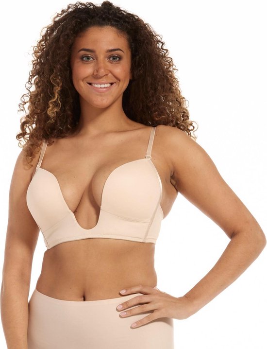 Vrouw met krullend haar draagt nude MAGIC Bodyfashion V-Bra met diepe V-uitsnijding.