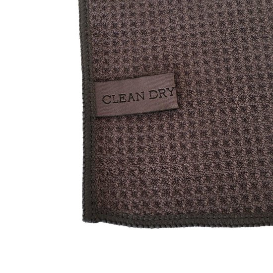 Donkergrijs doek met een wafelstructuur en een genaaid label met de tekst "CLEAN DRY".