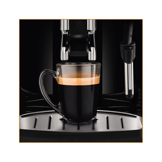 Glazen mok met latte macchiato en schuimlaag staat op rooster van zwarte espressomachine.