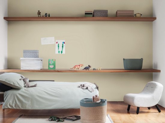 Lichte groene muur in een kinderkamer met bed, planken en een stoel.