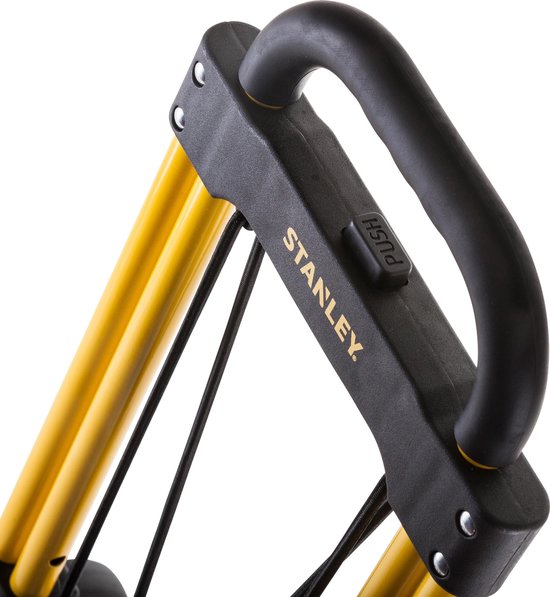Close-up van de zwarte handgreep met "STANLEY" logo en "PUSH" knop op gele stangen.