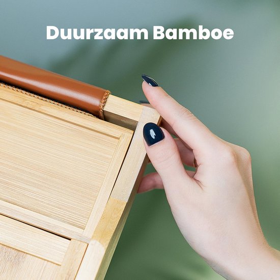 Close-up van een hand die de textuur van het bamboe materiaal van de badplank aanraakt.