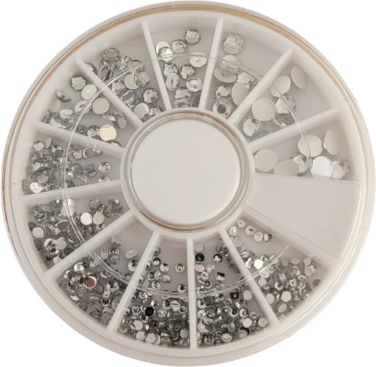 Ronde opbergdoos met vakjes gevuld met zilveren strass-steentjes voor nail art.