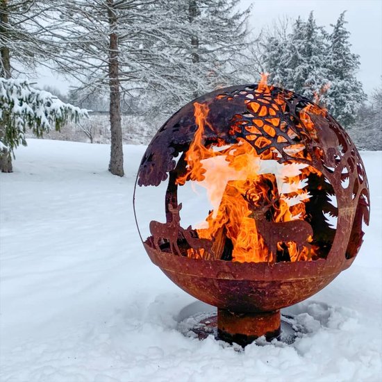 Roestbruine vuurschaal in bolvorm met open gesneden dieren en bomen, brandend in de sneeuw.