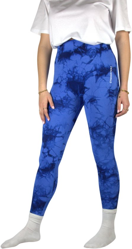 Model draagt een wit T-shirt en een blauwe tie-dye sportlegging met GYMHUNTERZ branding.