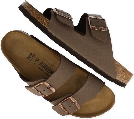 Paar bruine Birkenstock Arizona slippers, in een dynamische opstelling.