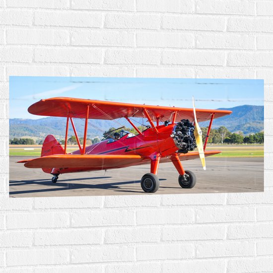 Muursticker - Rood Stuntvliegtuig Opstijgend vanuit Vliegbasis - 100x50 cm Foto op Muursticker