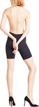 Model, achterkant gezien, draagt een zwarte short met ingeweven patroon en zwarte pumps.
