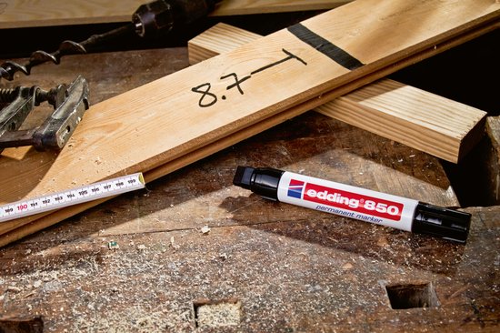edding 850 permanente marker op een werkbank met houten planken en meetgereedschap.