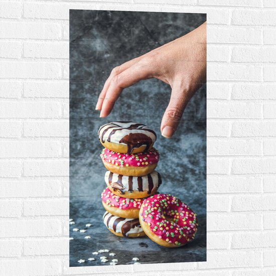Muursticker - Donuts - Gestapeld - Sprinkels - Hand - Kleurrijk - 50x100 cm Foto op Muursticker