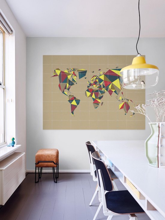 Carte du monde avec des motifs géométriques rouge, jaune et bleu, au-dessus d'une table à manger.
