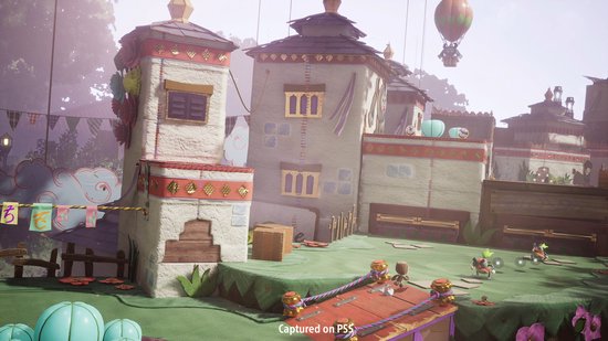 Een fantasiewereld met gebouwen in Tibetaanse stijl, een luchtballon en Sackboy die rent met kleurrijke personages.