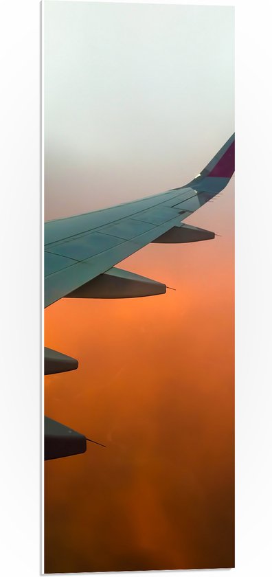 PVC Schuimplaat - Uitzicht op Vleugel van Vliegtuig in Oranjekleurige Mist - 30x90 cm Foto op PVC Schuimplaat (Met Ophangsysteem)