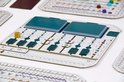 Speelbord met slots voor kaarten, een gouden pion en scoretellers, met blauwe kaarten erop.