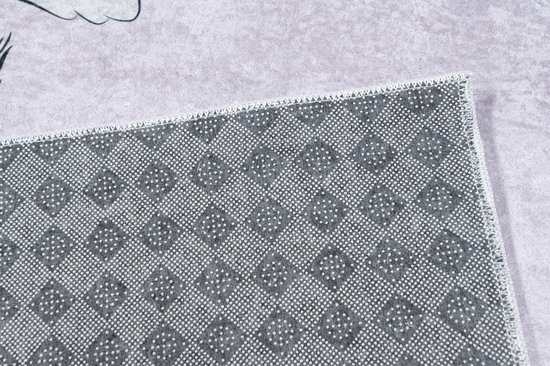 Dessous d'un tapis rose avec un motif antidérapant en forme de losange.