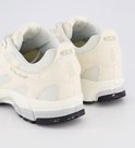 Crème Mercer sneakers met "MERCER" logo en ananas-detail op de hakken. Zwarte zolen met verfspatten.