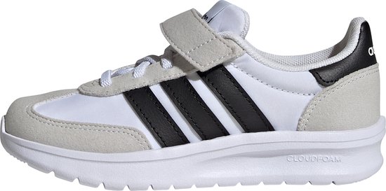 Vue latérale d'une basket blanche avec rayures noires, détails en suède et fermeture velcro.