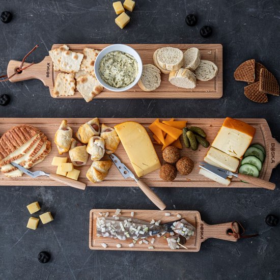 Houten serveerplanken met verschillende kazen, brood, hapjes en vis.