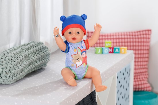 BABY born pop met blauwe muts en romper met beerprint. Met zwaaiende armen.