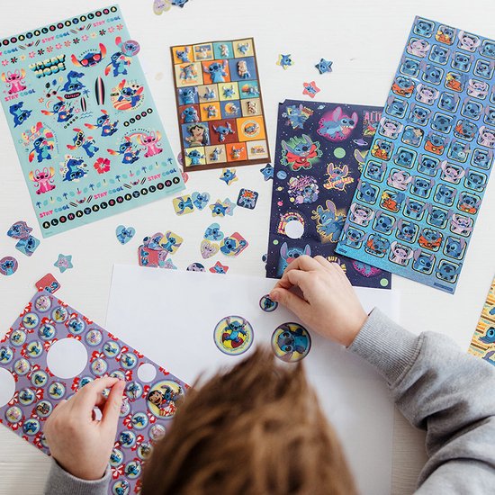 Plusieurs feuilles d'autocollants avec des images et des étoiles de Stitch sur une table blanche.