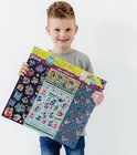 Garçon aux cheveux bouclés tenant un coffret de super autocollants Stitch avec 7 feuilles.