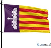 Mallorcaanse vlag wapperend aan een zwarte vlaggenmast. Rode en gele banen, paars vlak met wit kasteel.