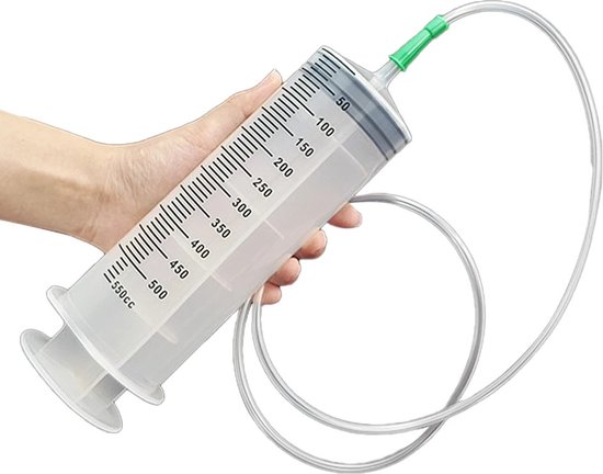 Een hand met een grote 550ml transparante spuit met meetmarkeringen, vastgehouden met een groene dop en een plastic slang.