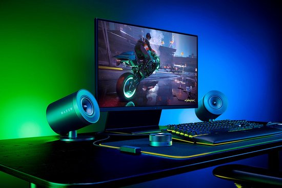 Gaming bureau met Razer speakers, toetsenbord en monitor met groen/blauw licht.