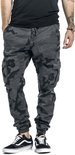 Mannelijke cargobroek met camouflageprint in grijs en zwart, met trekkoord en zakken. Gedragen met Vans sneakers.