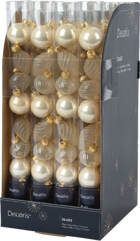 Boules de Noël dans leur emballage. Boules de Noël nacrées blanc perle brillantes et boules de Noël transparentes torsadées.