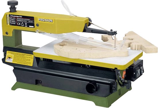 Gele Proxxon figuurzaag met groene basis, zaagt aan een houten figuur, met transparante kap.