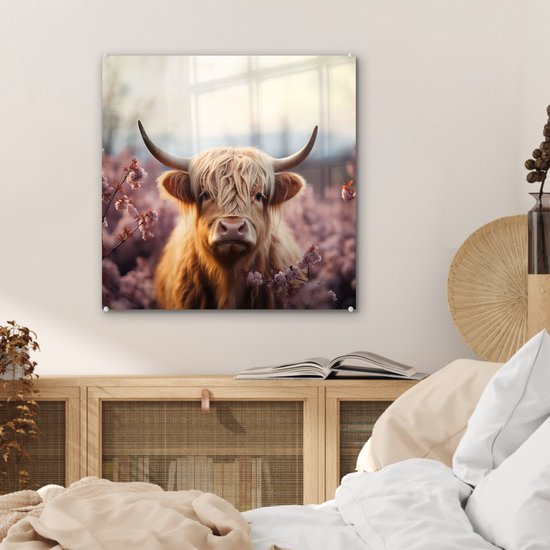 Glazen schilderij van een Schotse hooglander met lange, witte vacht, omringd door roze bloesems. Hangt boven een houten kast, in een slaapkamer.