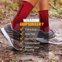 Pieds portant des chaussettes de sport rouges avec picots antidérapants, portées avec des chaussures de sport lors d'un entraînement.