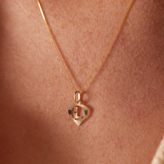 Gouden ketting met hartvormige hanger met de letter D.