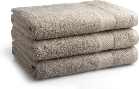 Stapel van drie beige badhanddoeken met een ribbelrand.